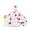 Organic cotton baby hat with repeat playful red dragons design printed on to white cotton fabric. Baby hat has a cute little hand tied knot at the top