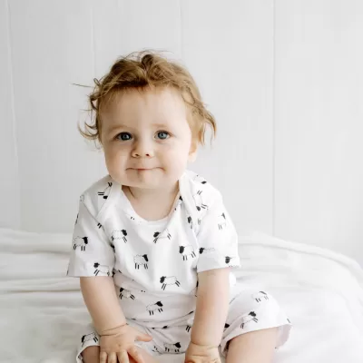 White short sleeved handmade organic cotton baby romper in our Welsh sheep design with fasteners at bottom for easy opening