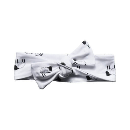 Organic cotton headband around the top of her head, with a bow in our black and white leaping lambs print. Made from GOTs certified organic cotton.