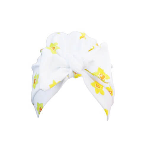 Handmade white organic cotton turban for baby or toddler with a bow in a vibrant daffodil design