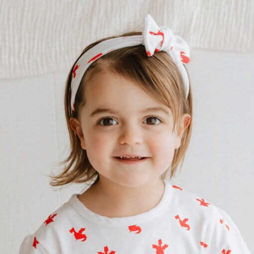 Infants handmade white organic cotton headband with a bow in our red dragon print