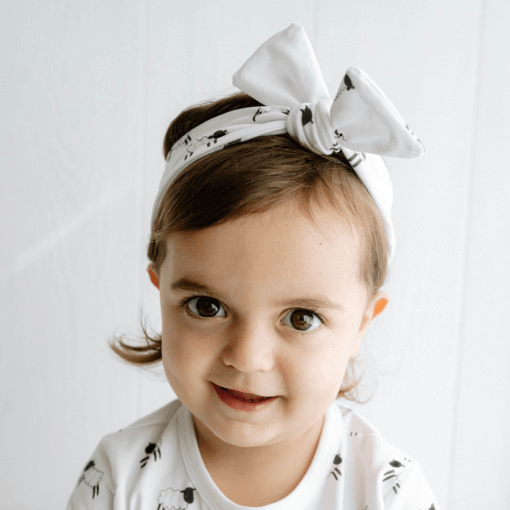 Infants handmade white organic cotton headband with a bow in our black and white sheep print