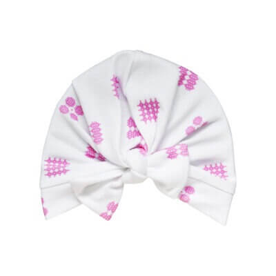 Handmade white organic cotton turban for baby or toddler with a bow in our pink tapestry celtic design