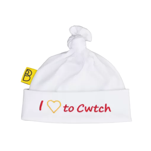 Welsh organic cotton baby hat embroidered with words I Love to Cwtch in red and a yellow embroidered heart instead of the word love